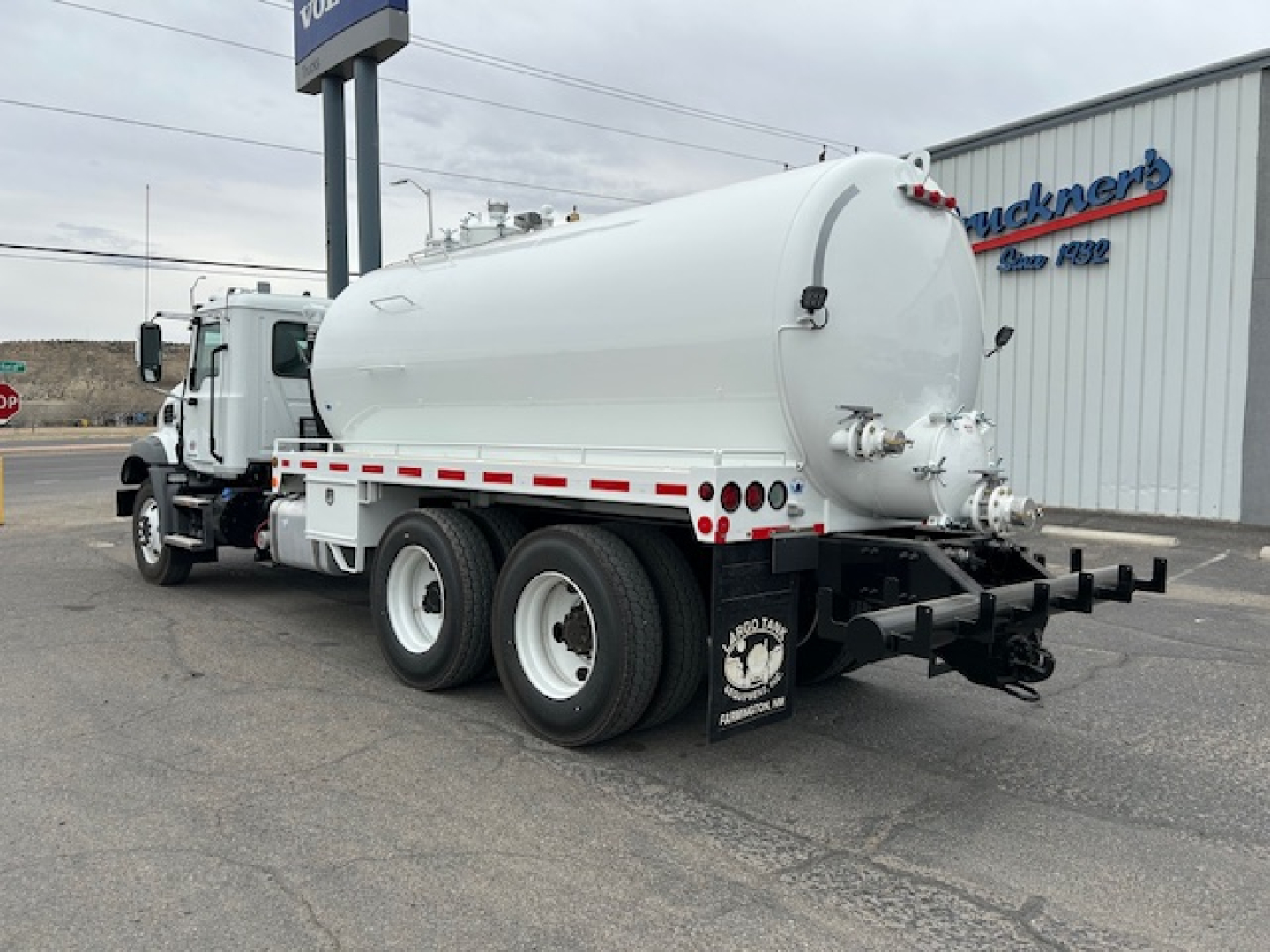 Mack GR64B vacuum tank truck rear three-quarter view showing cylindrical tank and dual rear axles.