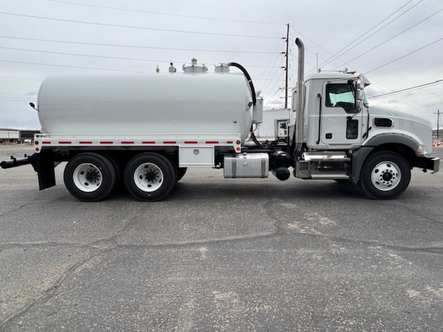 Mack GR64B vacuum tank truck side view showing cylindrical tank and cab with chrome exhaust