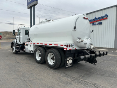 Mack GR64B vacuum tank truck rear three-quarter view showing cylindrical tank and dual rear axles.