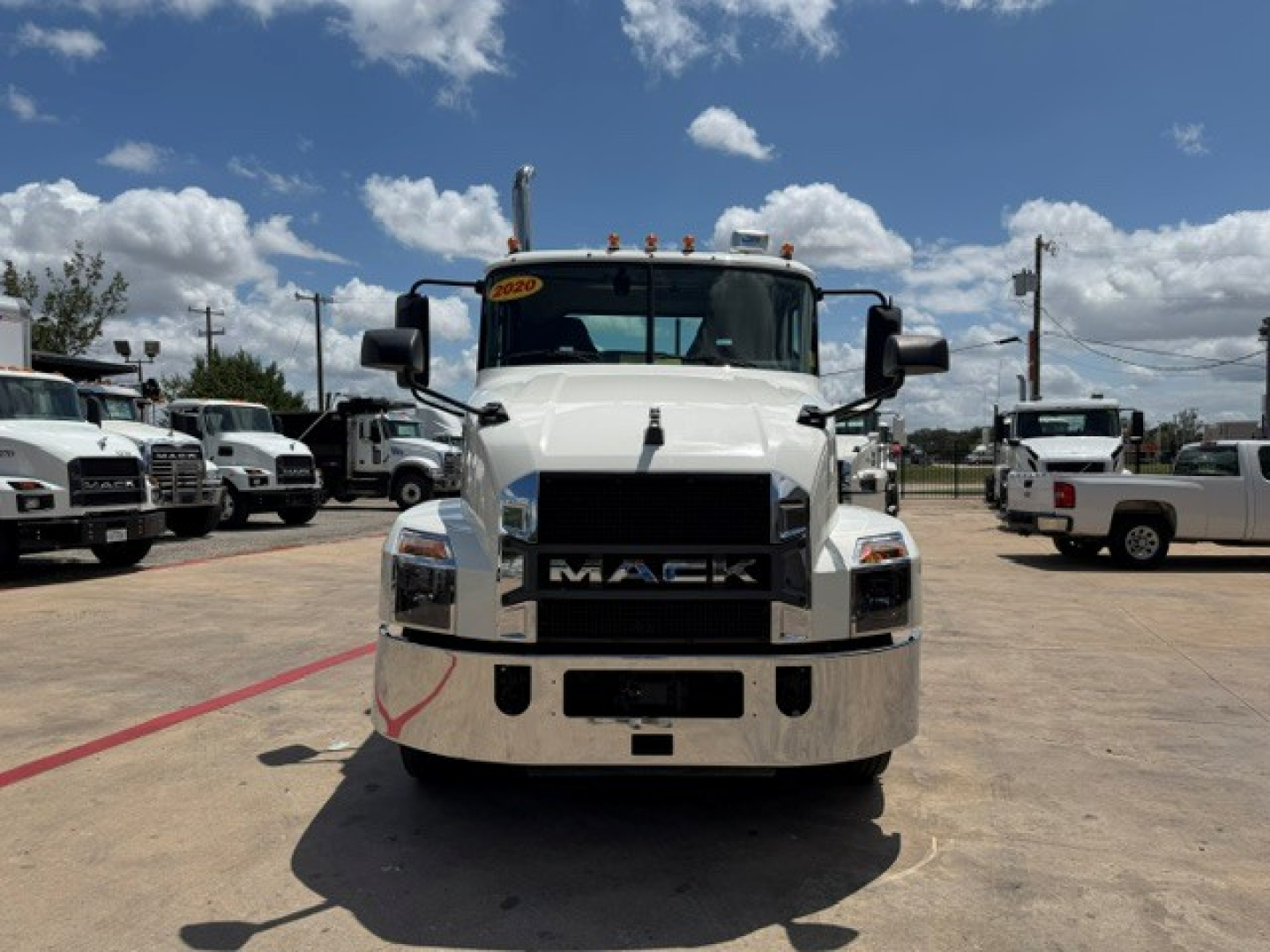 Front view of 2020 Mack AN64T conventional daycab truck in a dealership lot showing Mack grille and bumper; windshield with yellow inspection sticker
