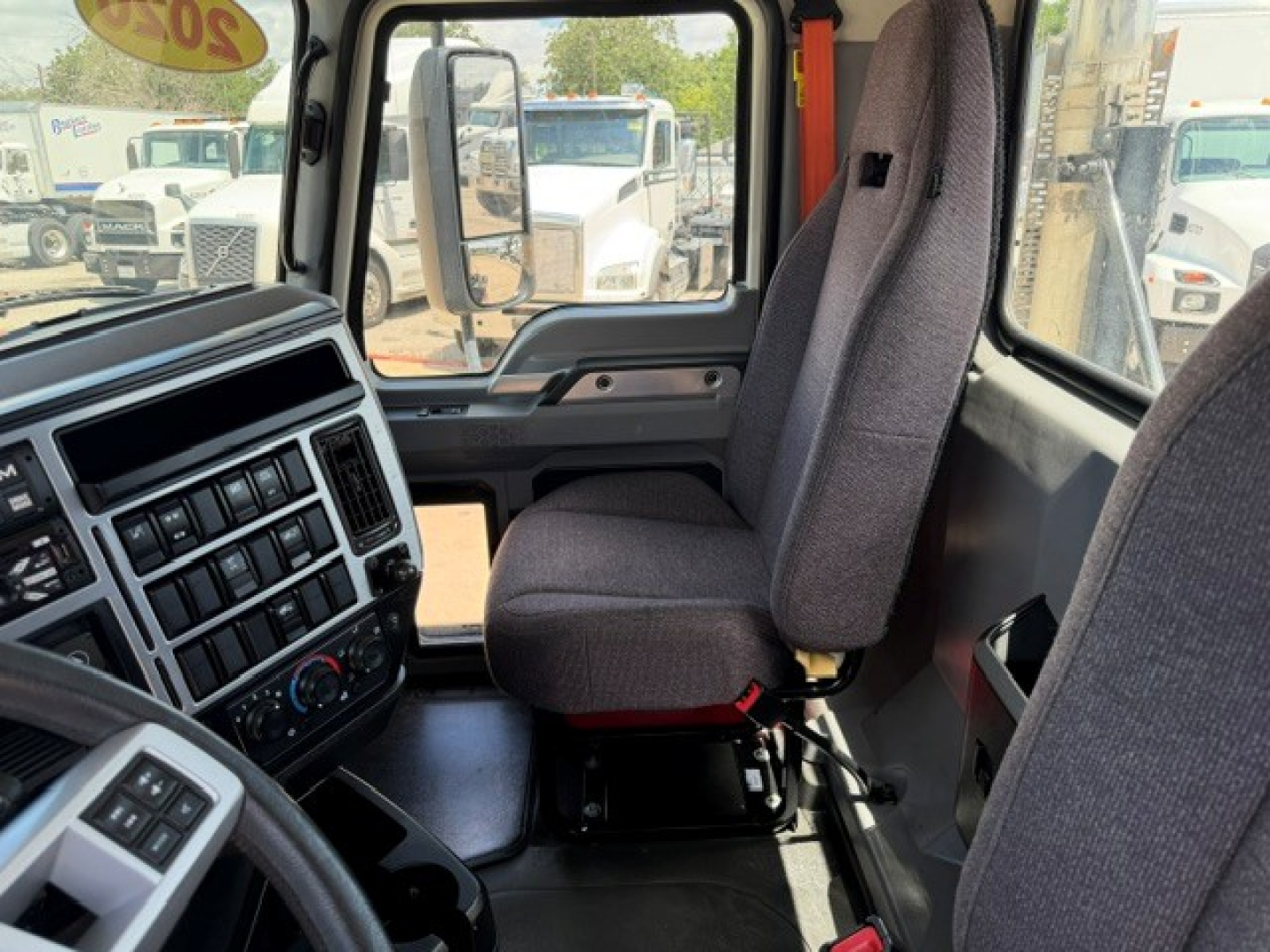 Truck cab interior showing driver and passenger seats and dashboard in a Mack AN64T truck.