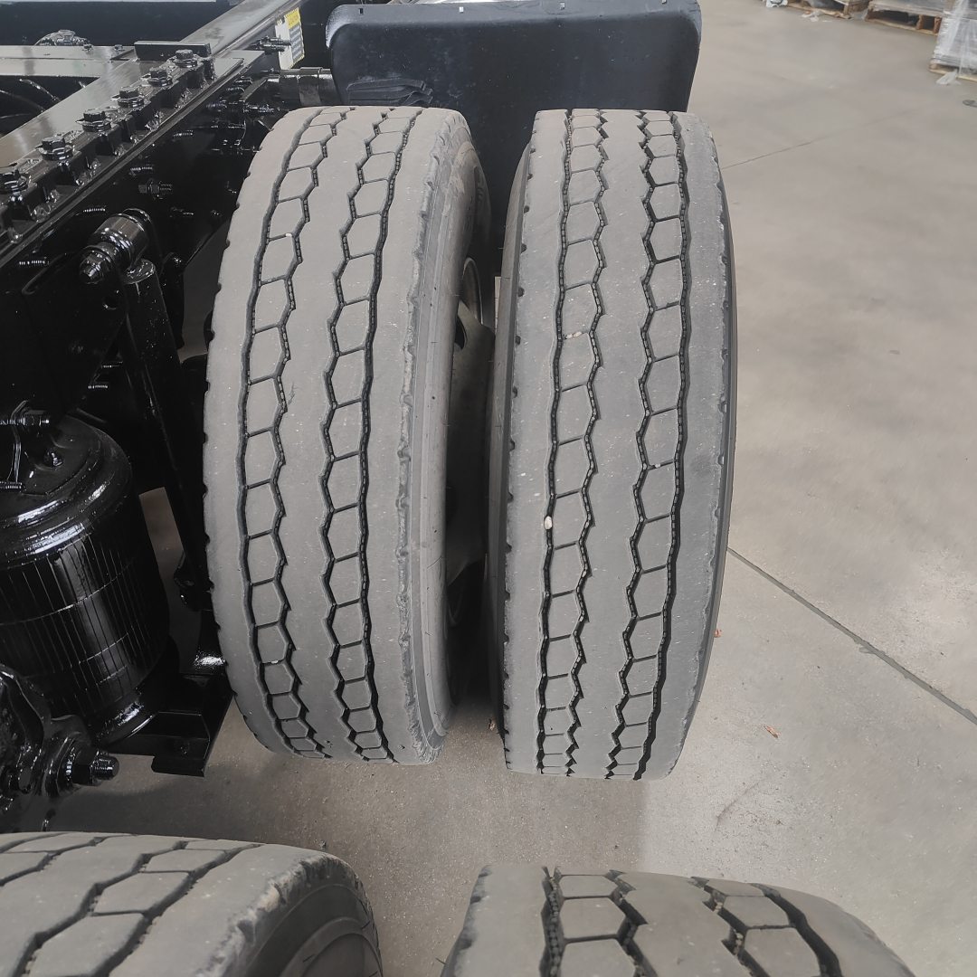 Dual rear truck tires on Mack AN64T chassis with visible tread pattern and suspension components