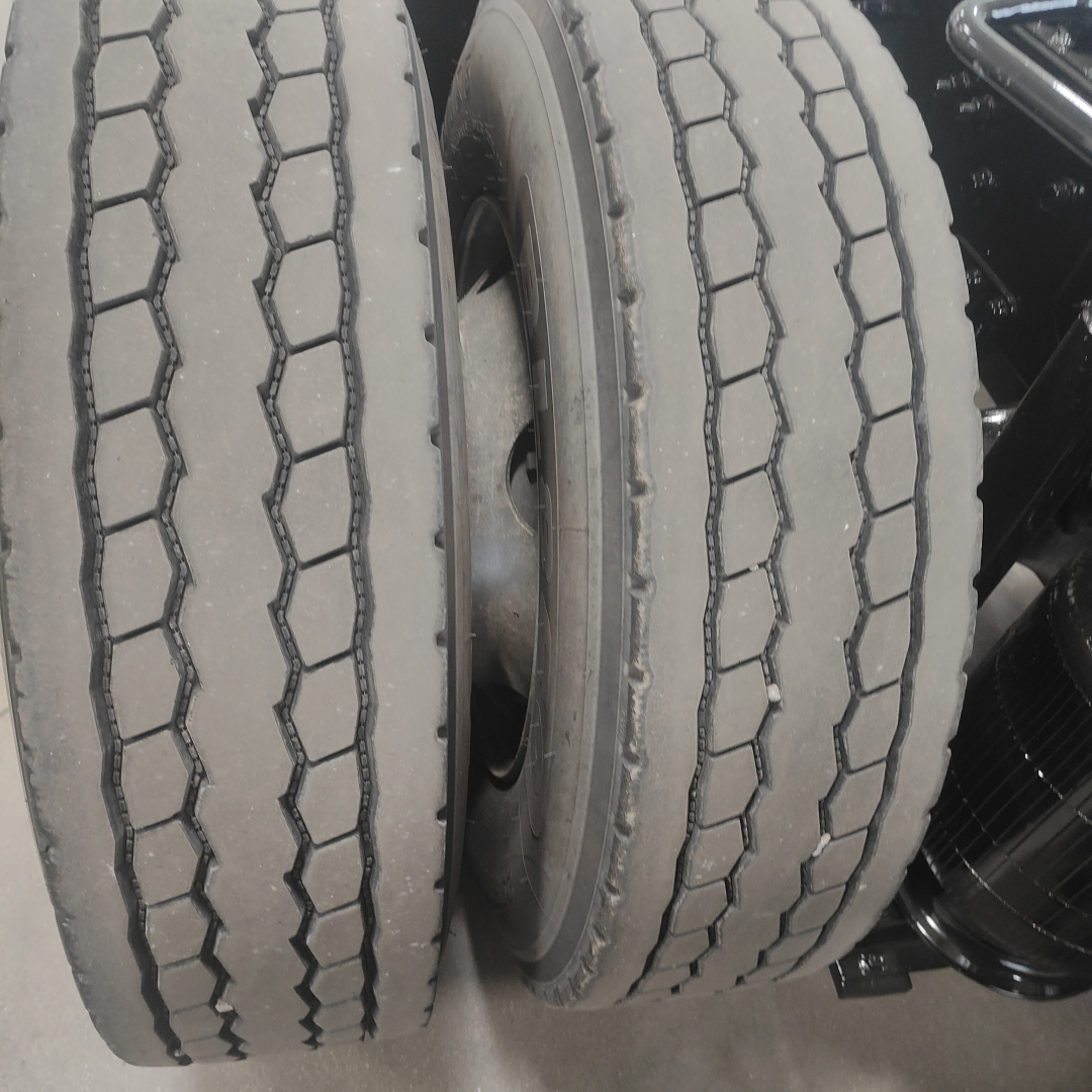Dual rear tires of a Mack AN64T tractor showing tread pattern and wheels.