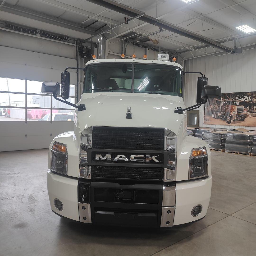Mack AN64T conventional daycab front view showing bold grille with MAC K letters and large bumper in white.