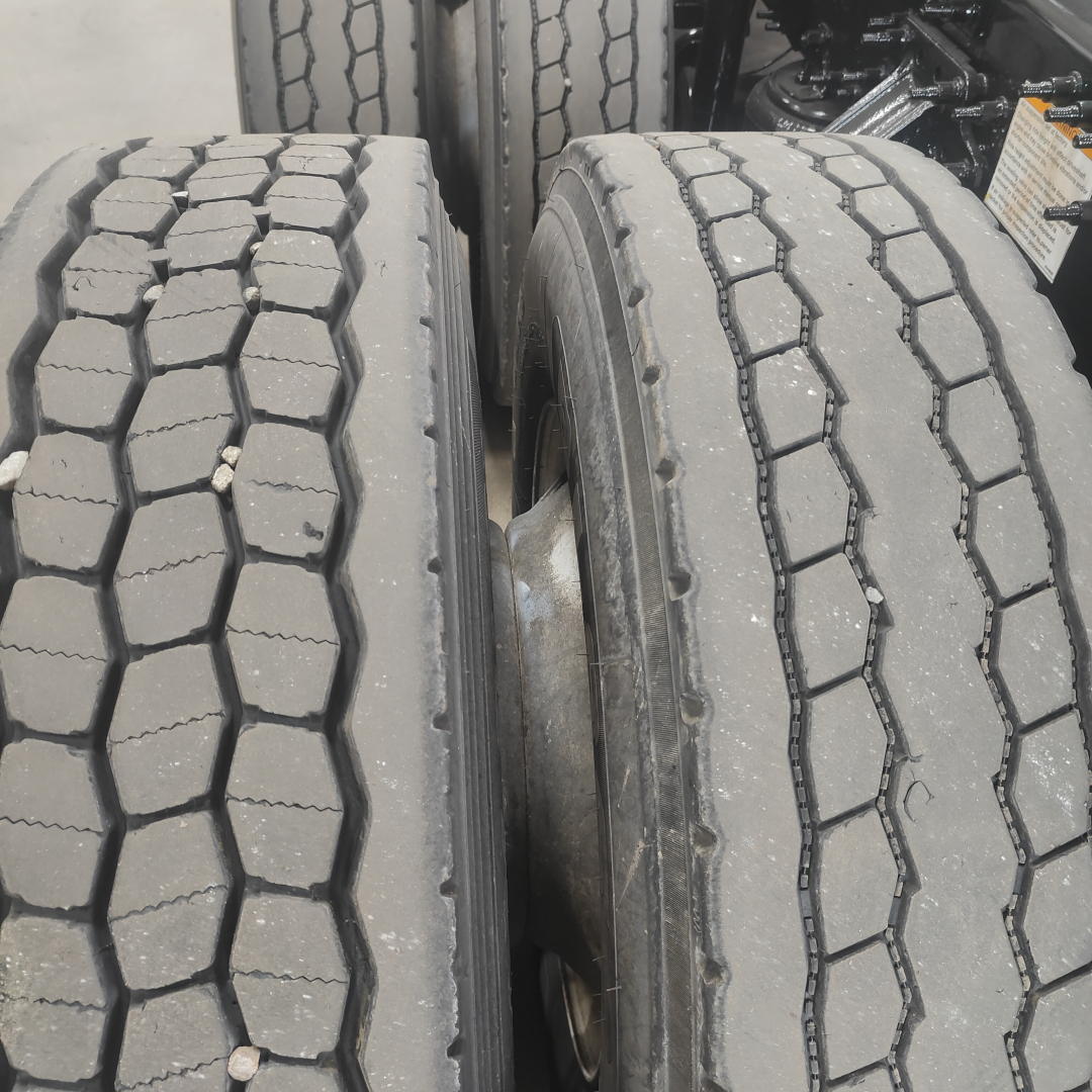 Tandem axles with dual tires on a Mack AN64T truck showing tread patterns and wheel rims.