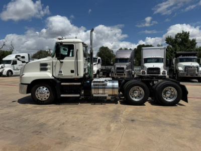 Conventional daycab truck chassis with dual rear axles and aluminum fuel tank, 2020 Mack AN64T, side view.