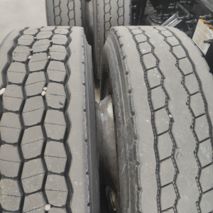Tandem axles with dual tires on a Mack AN64T truck showing tread patterns and wheel rims.