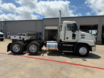 Truck side view of a 2020 Mack AN64T conventional daycab showing rear axle configuration and exhaust stack.