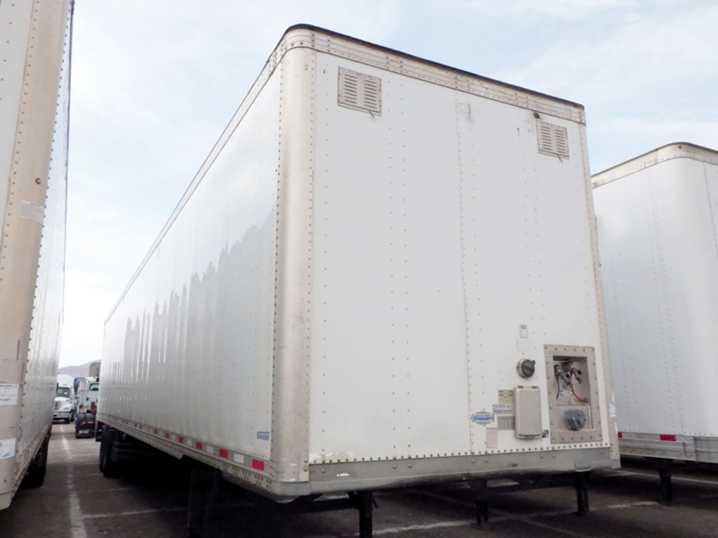 Trailer rear/side view showing 2020 Vanguard aluminum dry van trailer with smooth sides, v-nose front, rear access door, and utility box.