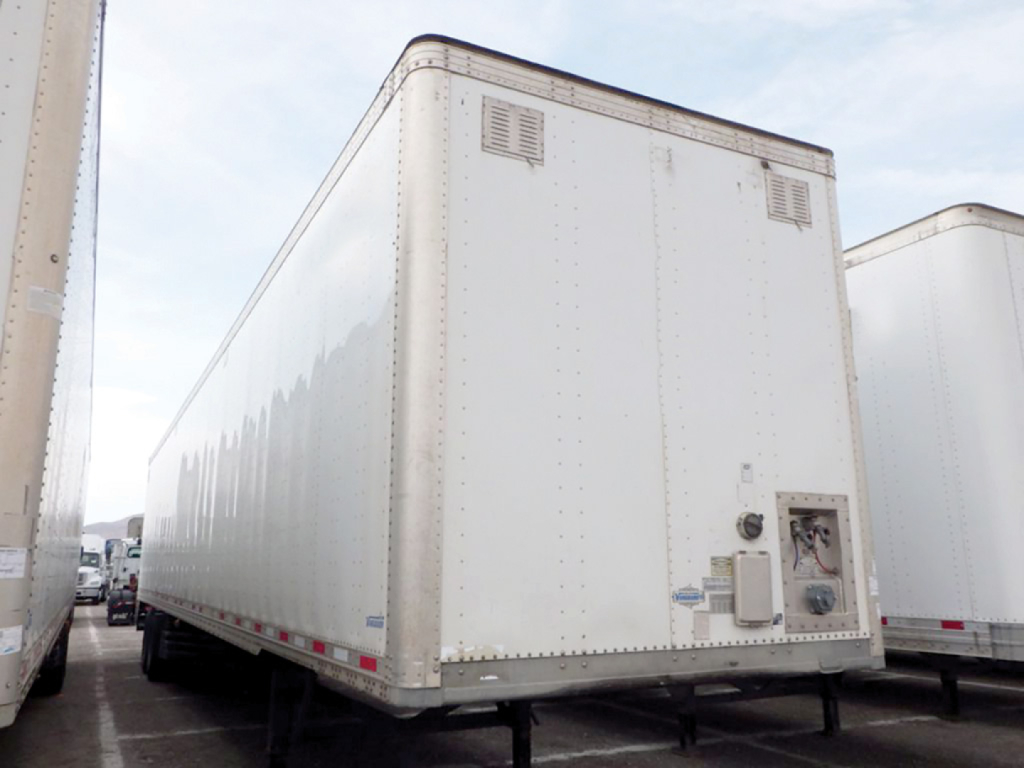 Trailer rear/side view showing 2020 Vanguard aluminum dry van trailer with smooth sides, v-nose front, rear access door, and utility box.