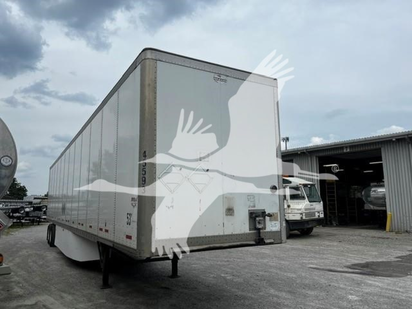 Trailer side view showing a white 2017 Wabash dry van trailer with registration numbers and rear doors.