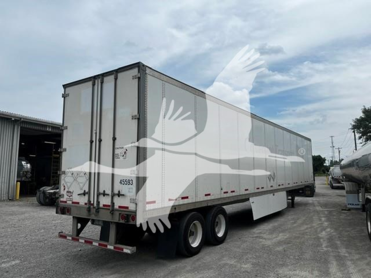 Wabash dry van trailer showing rear doors and tandem axles with reflective tape.