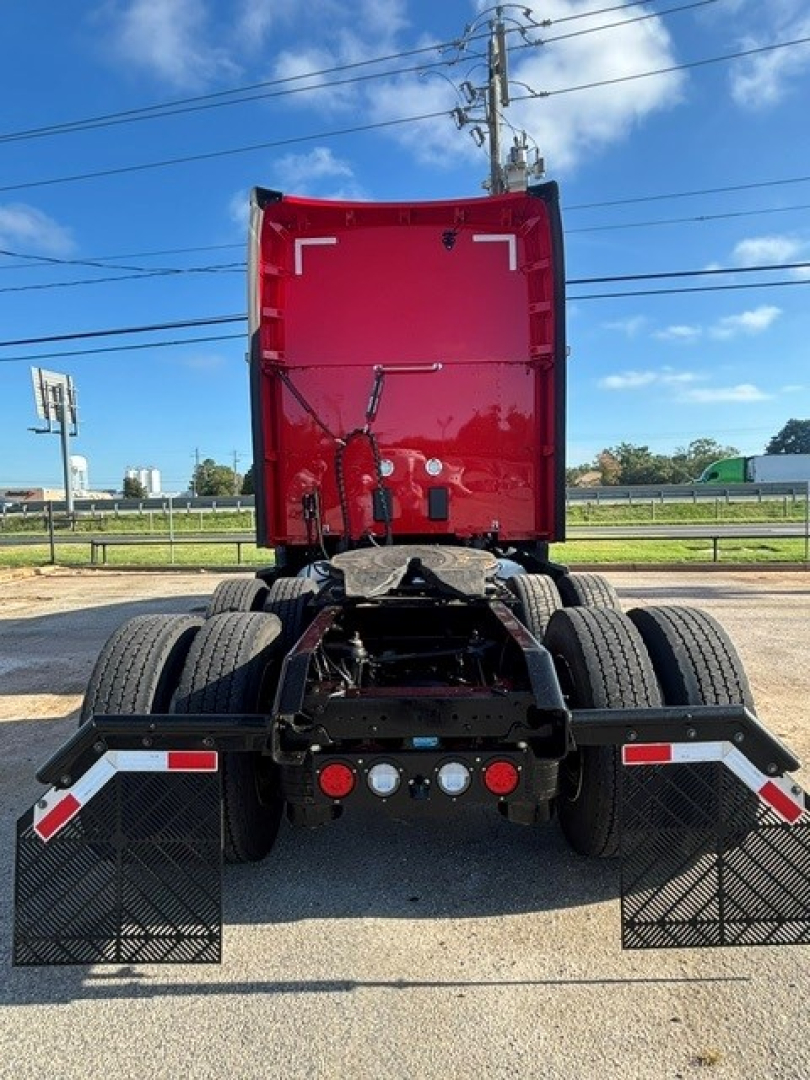 Kenworth T680 truck rear view showing fifth-wheel, dual rear axles, mudflaps, and fuel lines with red sleeper cab.