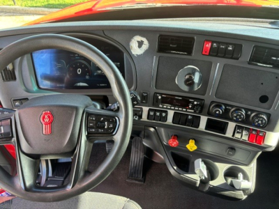 Kenworth T680 interior cockpit showing steering wheel, gauge cluster, center console, and dashboard controls.