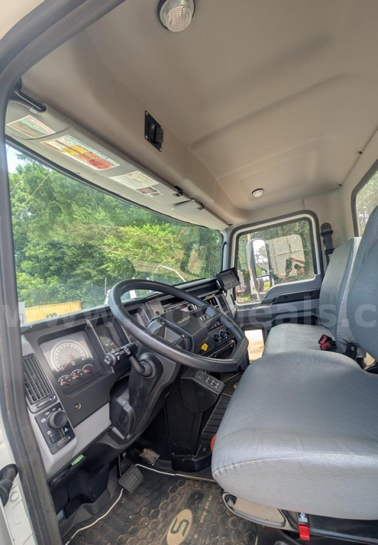 Mack MD cab interior showing steering wheel, dashboard gauges, and gray fabric seat.
