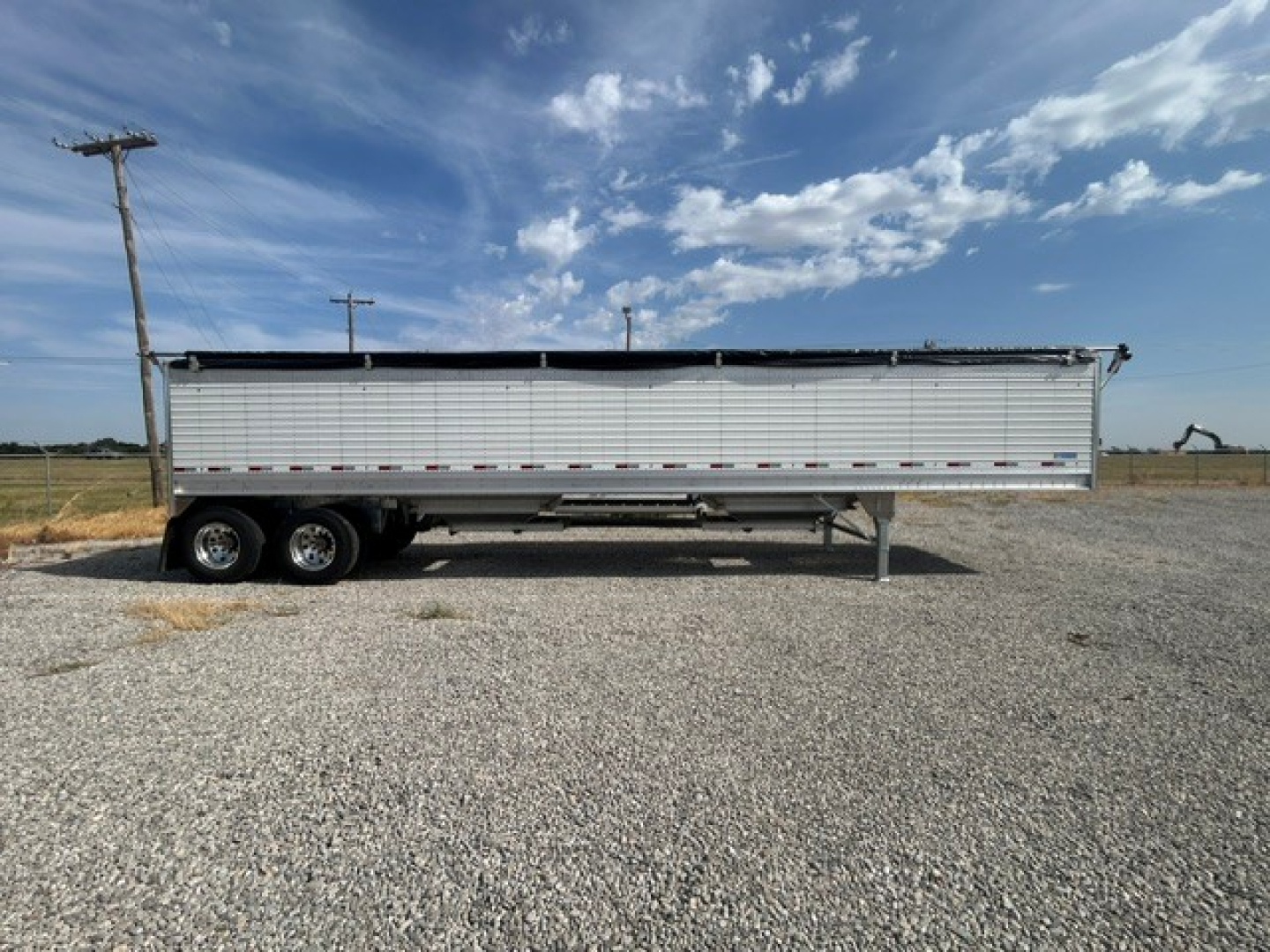 Trailer side view showing 40' aluminum grain hopper with 68" corrugated sidewalls, tandem axles, and landing gear.