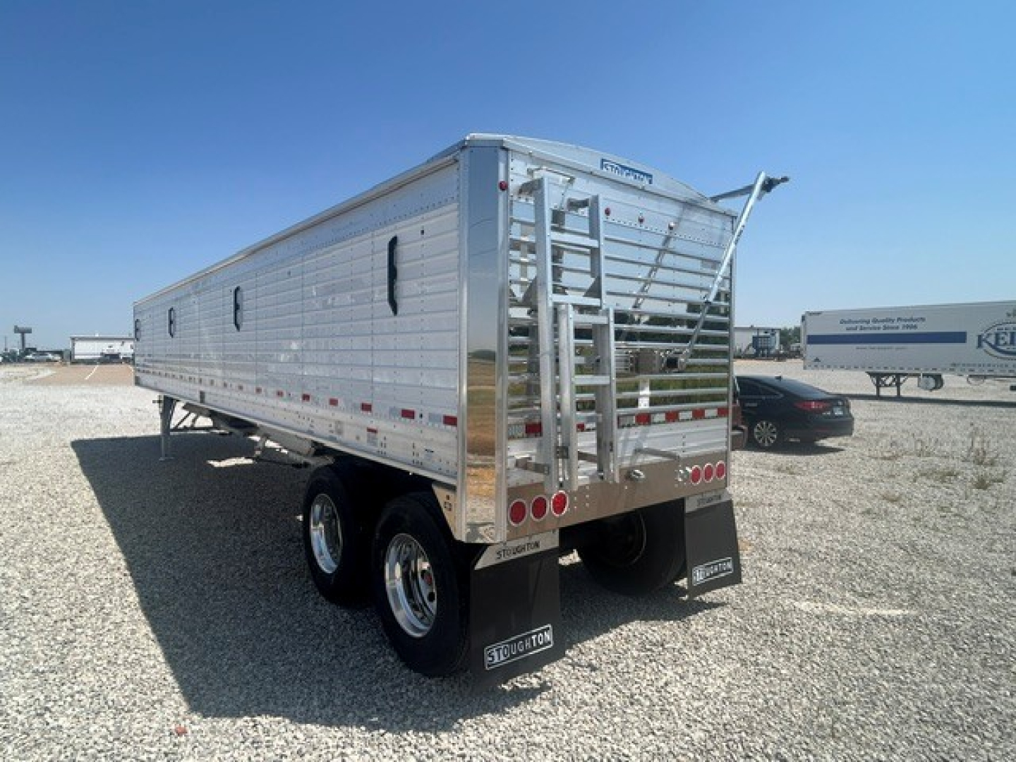 Stoughton 40' aluminum grain hopper trailer with corrugated 68" sidewalls, rear ladder, dual axles, and ramp gates.