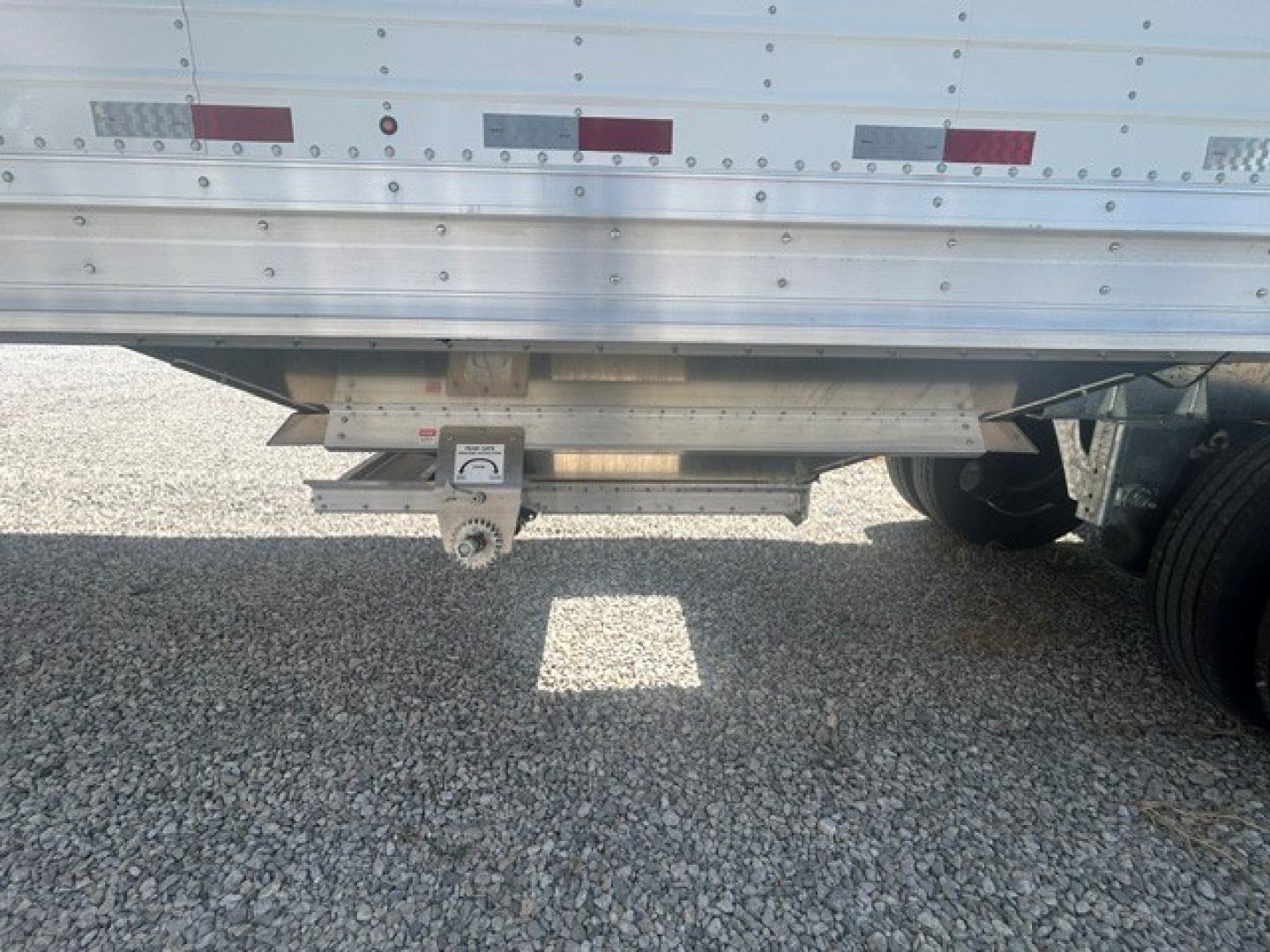 Trailer hitch area of a 2027 Stoughton 40' aluminum grain hopper showing 68" corrugated sidewalls, trailer hitch, and undercarriage components.