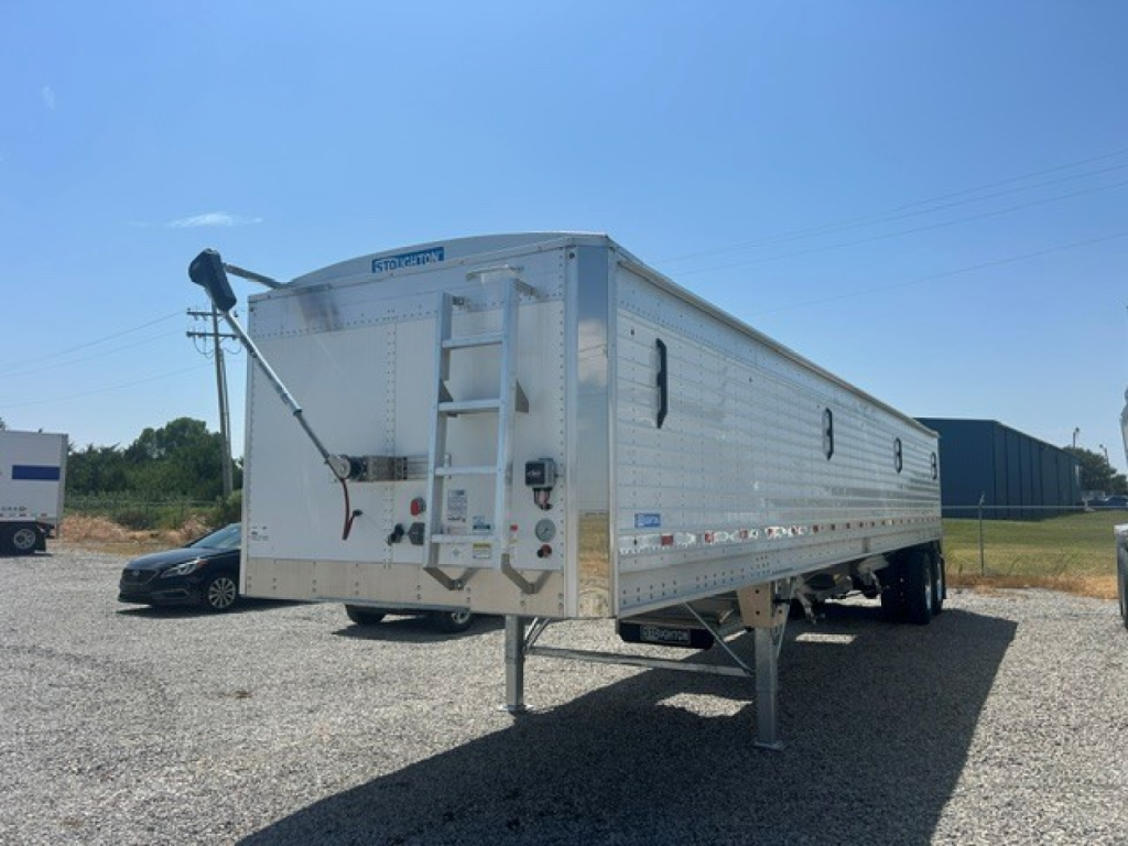 Trailer side view showing 40-foot aluminum grain hopper with corrugated sidewalls and rear entry ladder.