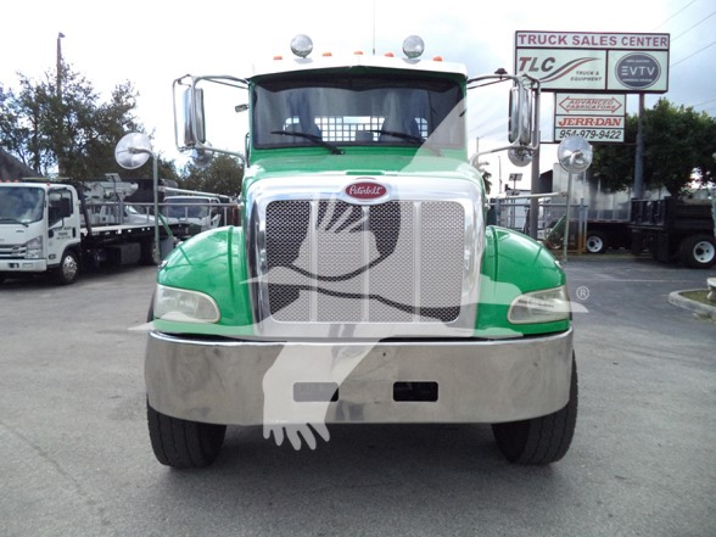 Peterbilt 348 rollback truck front view with green cab and chrome grille.