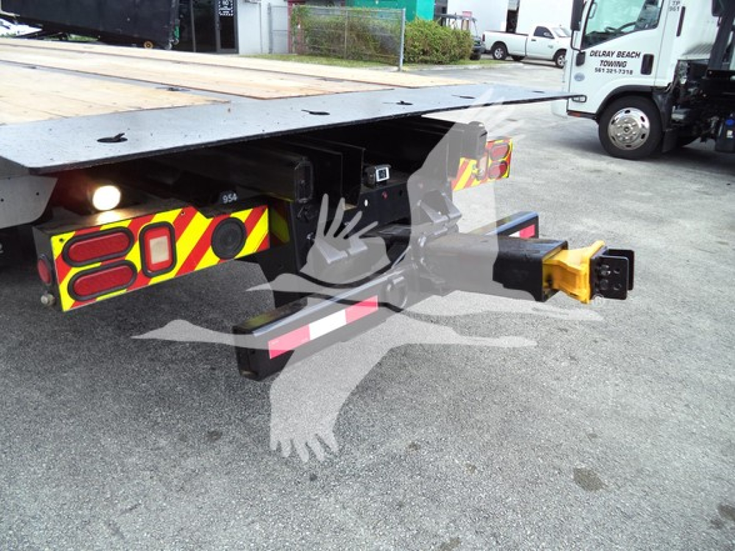 Peterbilt 348 rollback truck hitch and platform showing rear undercarriage, safety reflective chevrons, and yellow hitch pin.