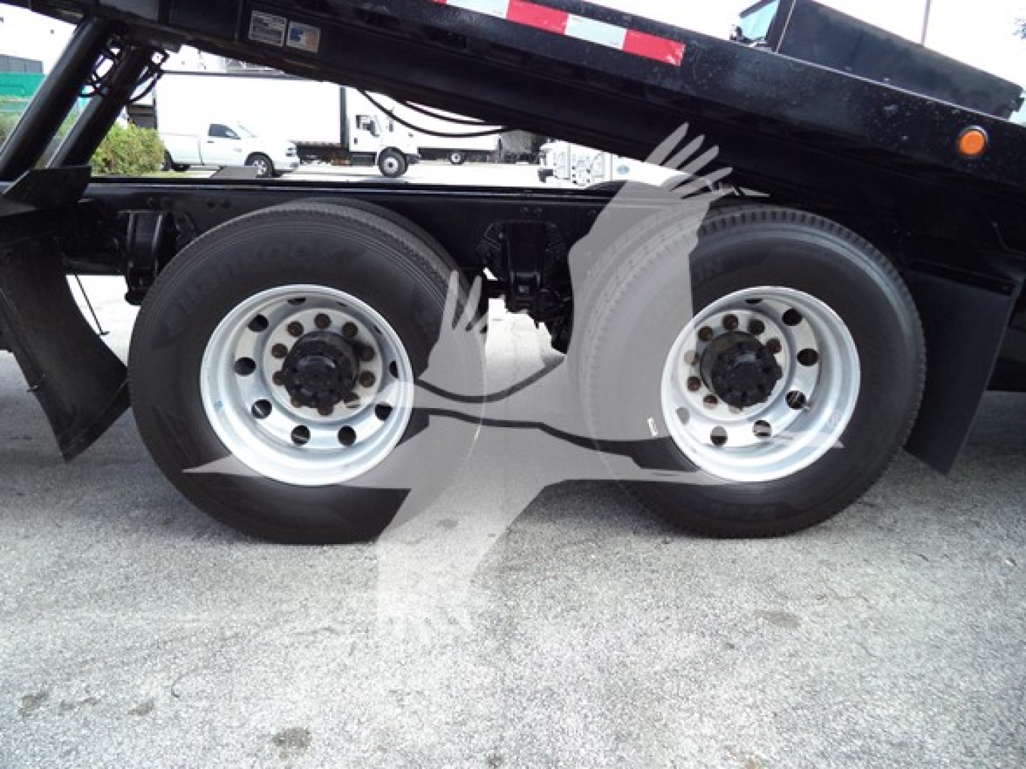 Two rear axles of a Peterbilt 348 rollback truck with dual wheels and metal rims. No visible text legible on tires or components.