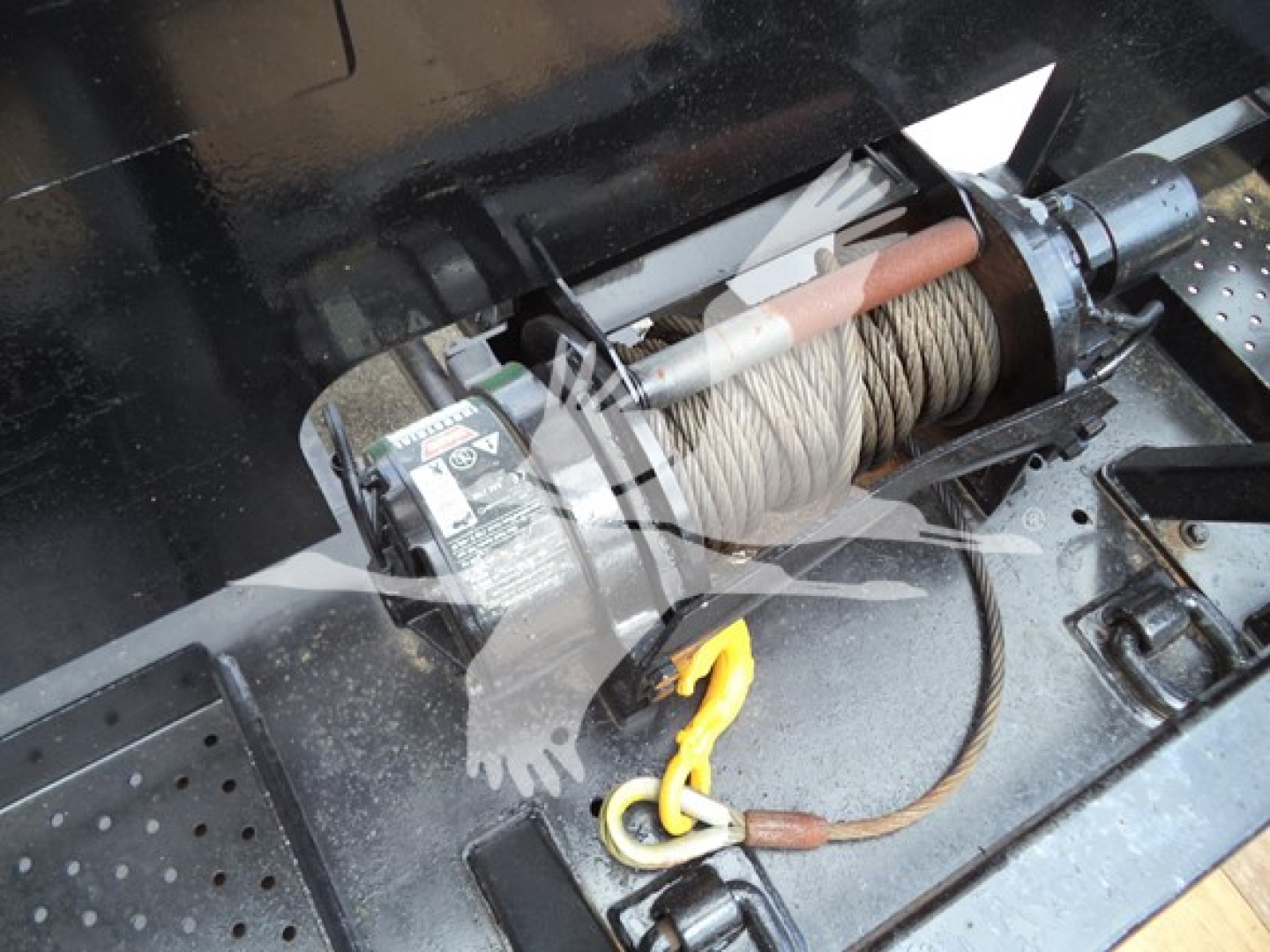 Winch and cable system on rollback truck with hook and pulley visible