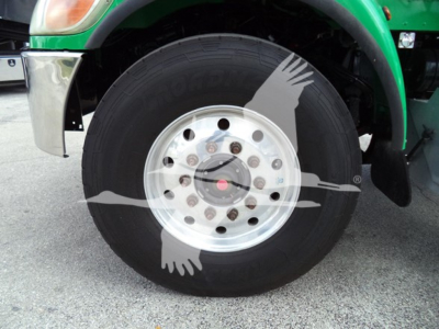 Truck wheel and hub assembly of a 2016 Peterbilt 348 rollback truck showing front tire and rim with hub nuts.
