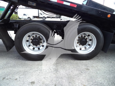 Two rear axles of a Peterbilt 348 rollback truck with dual wheels and metal rims. No visible text legible on tires or components.