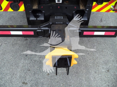 Peterbilt 348 rollback with rear hitch and yellow gooseneck coupling, showing mounting hardware and reflective safety tape