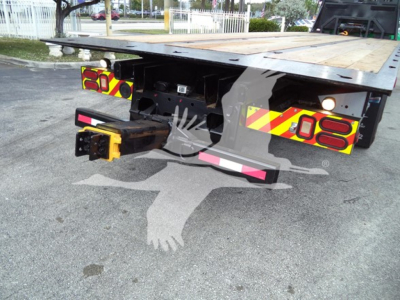 Rear view of a Peterbilt 348 rollback truck showing bumper, taillights, and hitch assembly with warning lights and reflective tape.