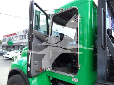 Peterbilt 348 rollback truck cab interior and open door showing driver seat and steps, green exterior, with VIN and stock number text in listing context.
