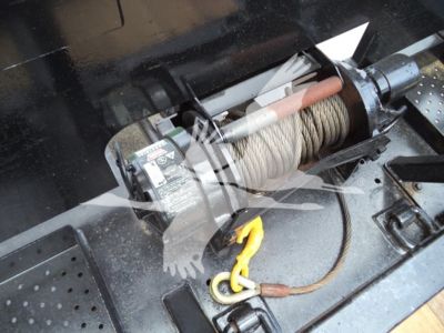 Winch and cable system on rollback truck with hook and pulley visible