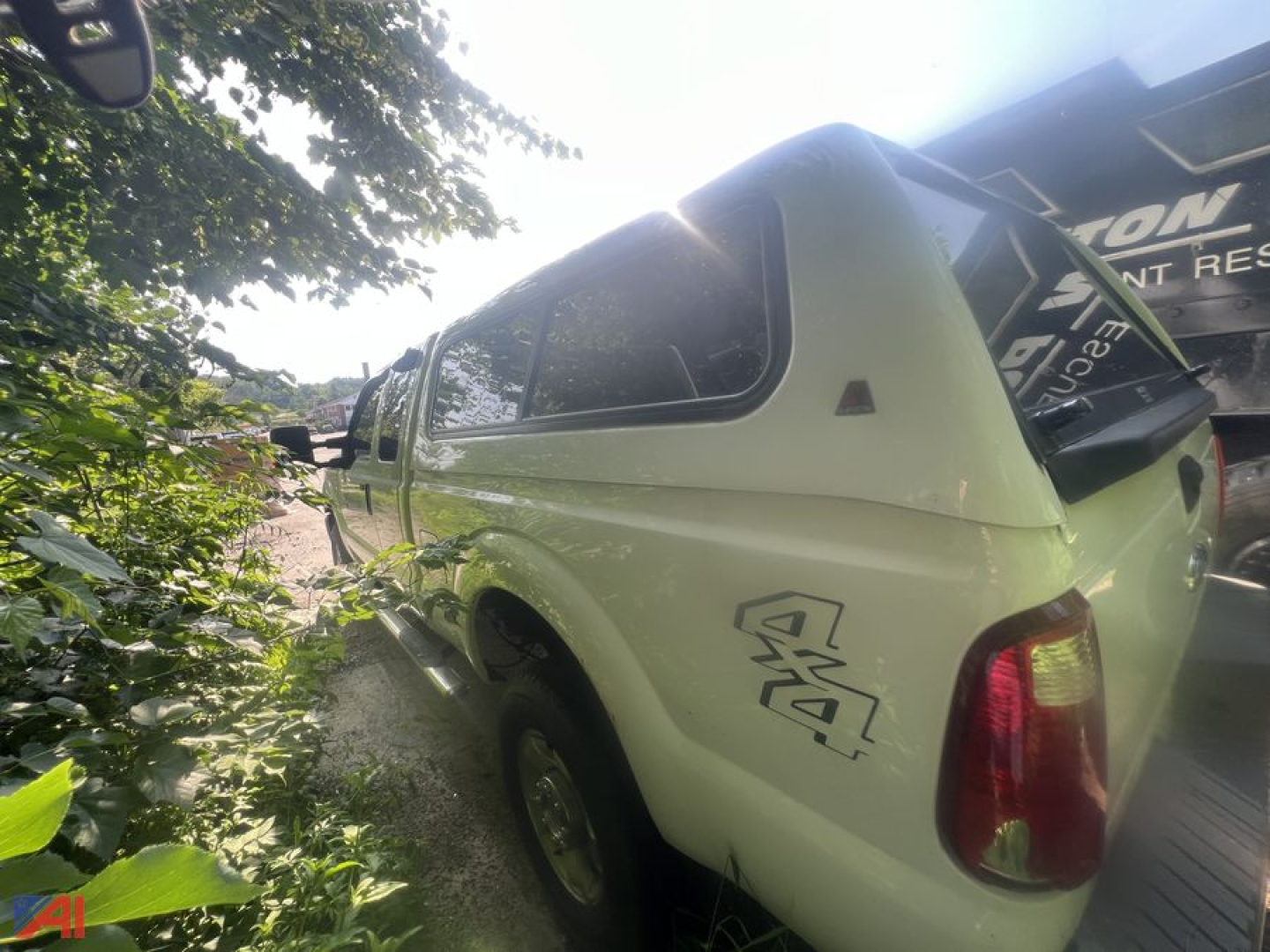 2015 Ford F-250 Super Duty extended cab pickup with cap, side view showing rear quarter and cap window.