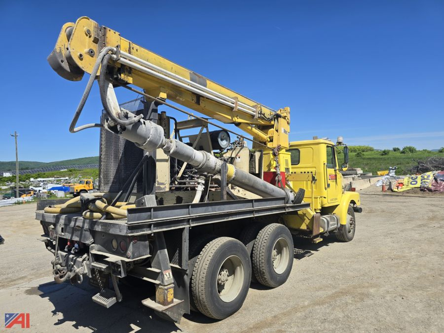 GMC WG core bore drill truck with yellow derrick on a heavy- equipment trailer.