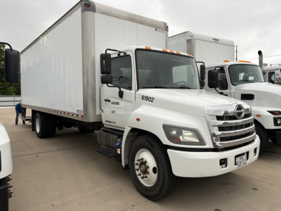 Truck cab and box trailer of a 2019 Hino 268A in a dealership lot, white body, dual rear wheels, inventory number 61902 visible on door.