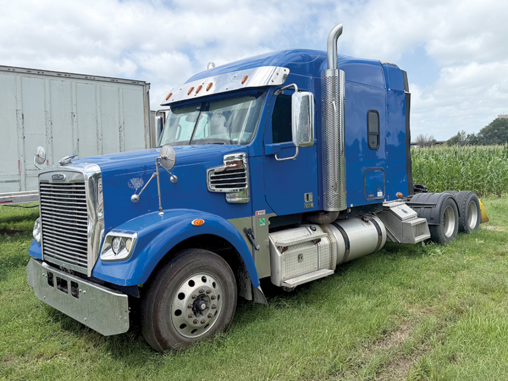 Freightliner Coronado SD122 front three-quarter view showing blue sleeper cab and chrome grille.
