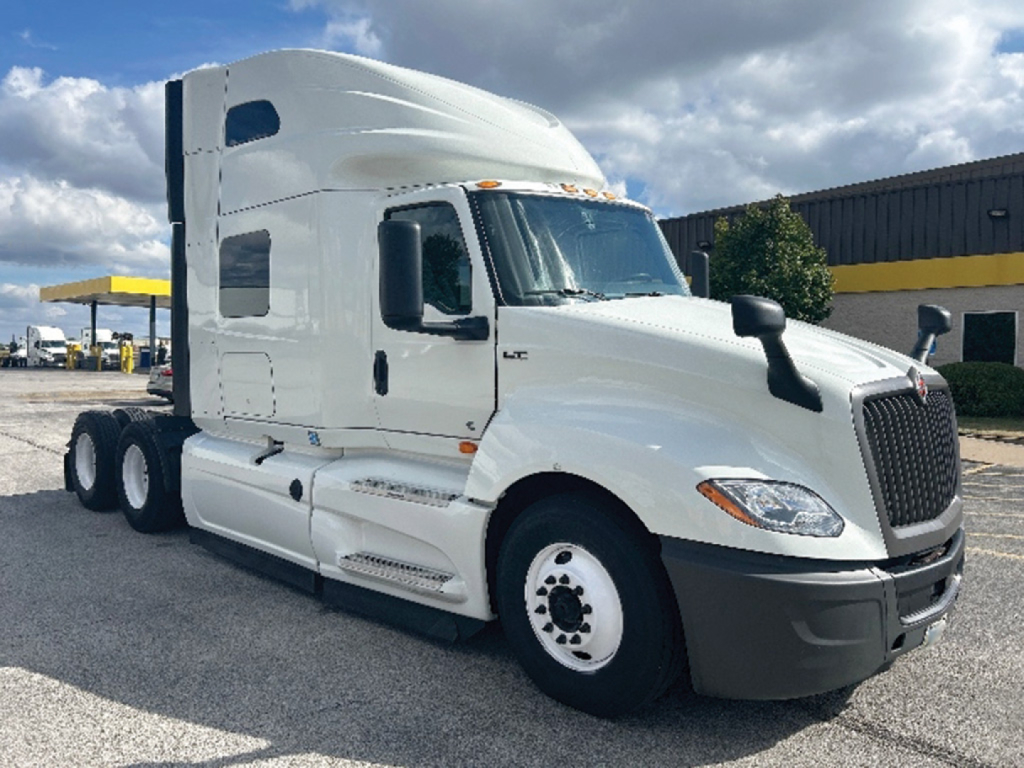 Truck showing International LT cab and sleeper with six-wheel configuration, front grille, side mirrors, and steps.
