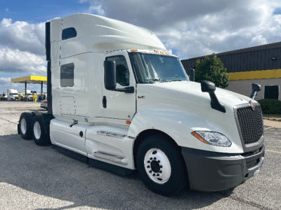 Truck showing International LT cab and sleeper with six-wheel configuration, front grille, side mirrors, and steps.