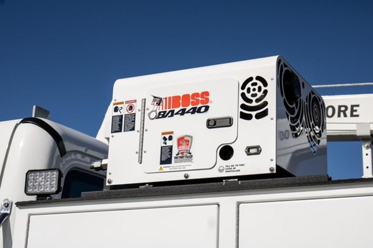 Freightliner M2 106 Plus service truck equipment: portable generator unit labeled JOBOSS QF1440 mounted on truck bed with control panel and safety stickers.