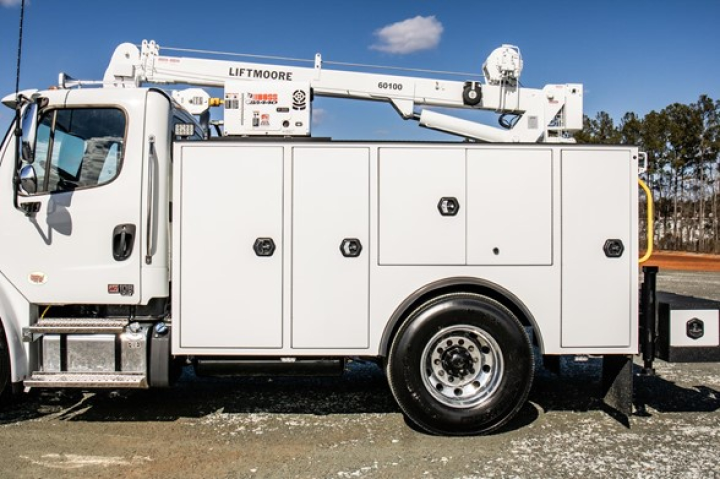 Service/utility truck side view showing Liftmoore boom and multiple storage compartments on Freightliner M2 106 Plus.
