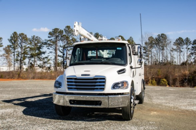 Freightliner M2 106 Plus service/utility truck in white, front view with boom lift, no visible text on truck