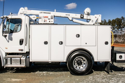 Service/utility truck side view showing Liftmoore boom and multiple storage compartments on Freightliner M2 106 Plus.