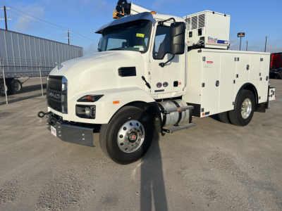 Service/utility truck side view showing white Mack MD6 with storage compartments and rooftop equipment.
