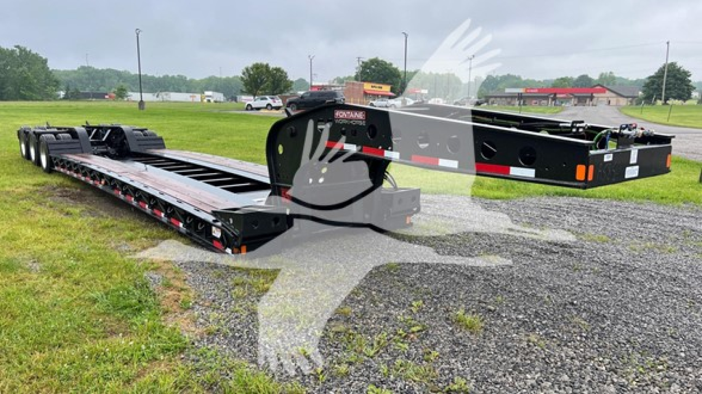 Lowboy trailer showing Fontaine 55 Lcc chassis and deck with black finish and multiple axles.