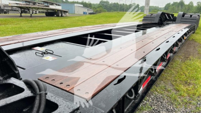 Lowboy trailer deck with raised wood and metal sections, viewed from side showing red wheels and axles; Fontaine branding faint on surface.