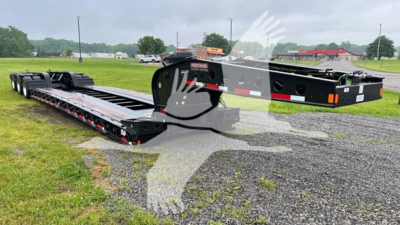 Lowboy trailer showing Fontaine 55 Lcc chassis and deck with black finish and multiple axles.
