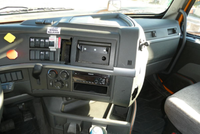 Volvo VNR64T300 cab interior showing dashboard controls and steering area with empty radio slot and various gauges.