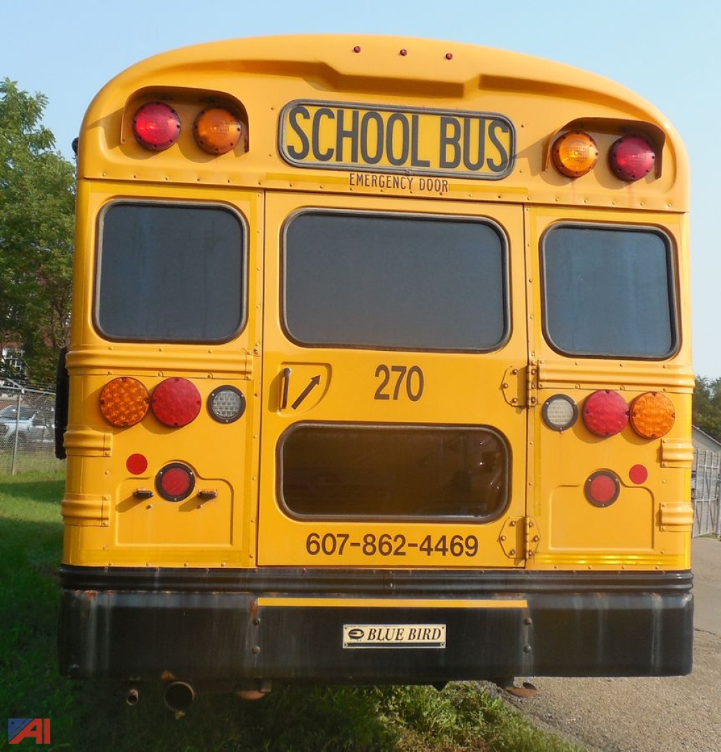 Rear view of a yellow 2018 Blue Bird Vision school bus showing taillights, emergency door label, bus number 270, and contact phone on the back.