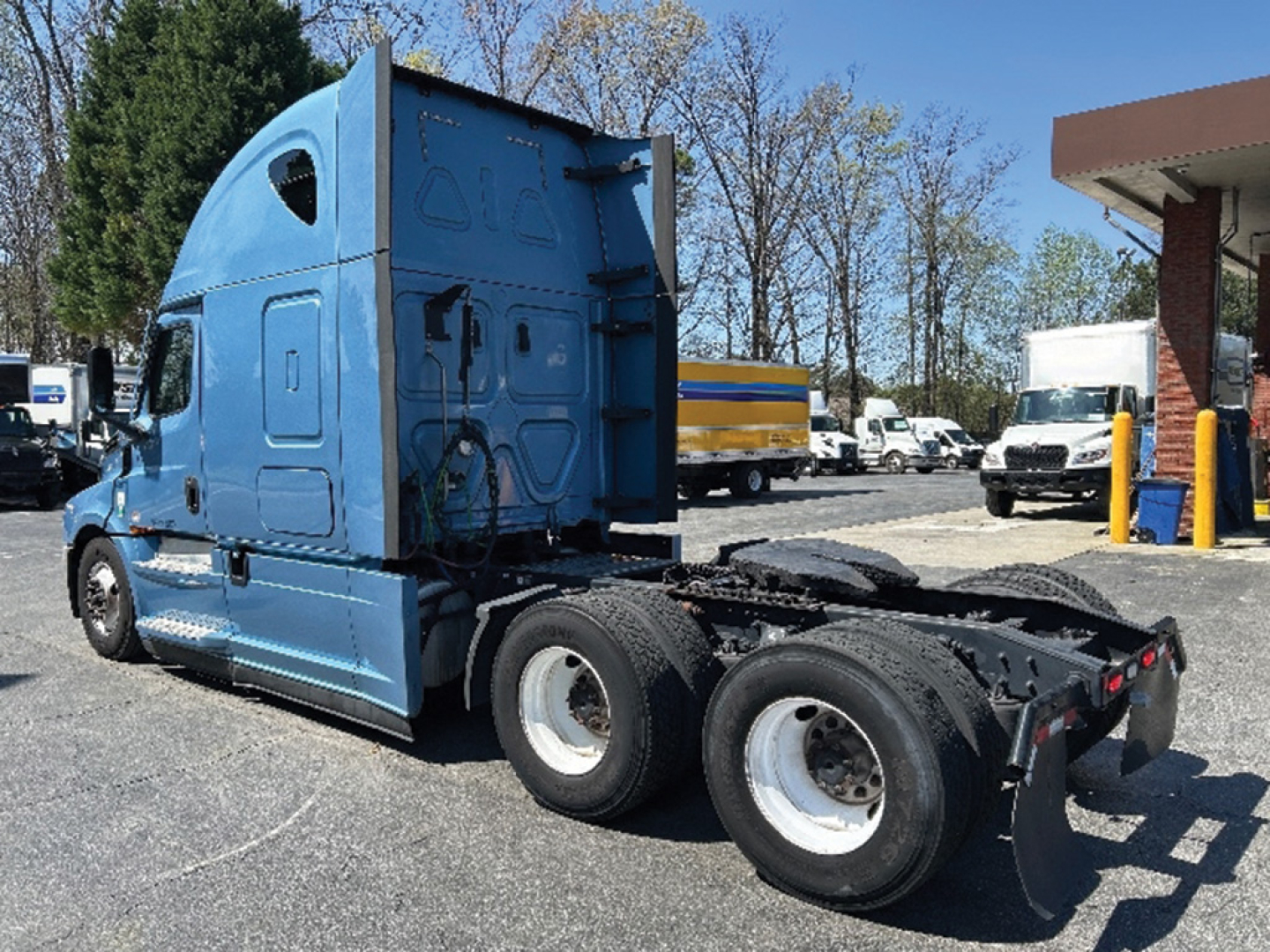 2022 Freightliner Cascadia126 truck tractor shown from rear-side angle, with blue cab and twin rear axles, fifth-wheel area visible.